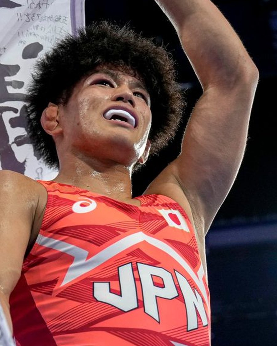 Kotaro Kiyooka in his Japan singlet, arms raised after his Paris final